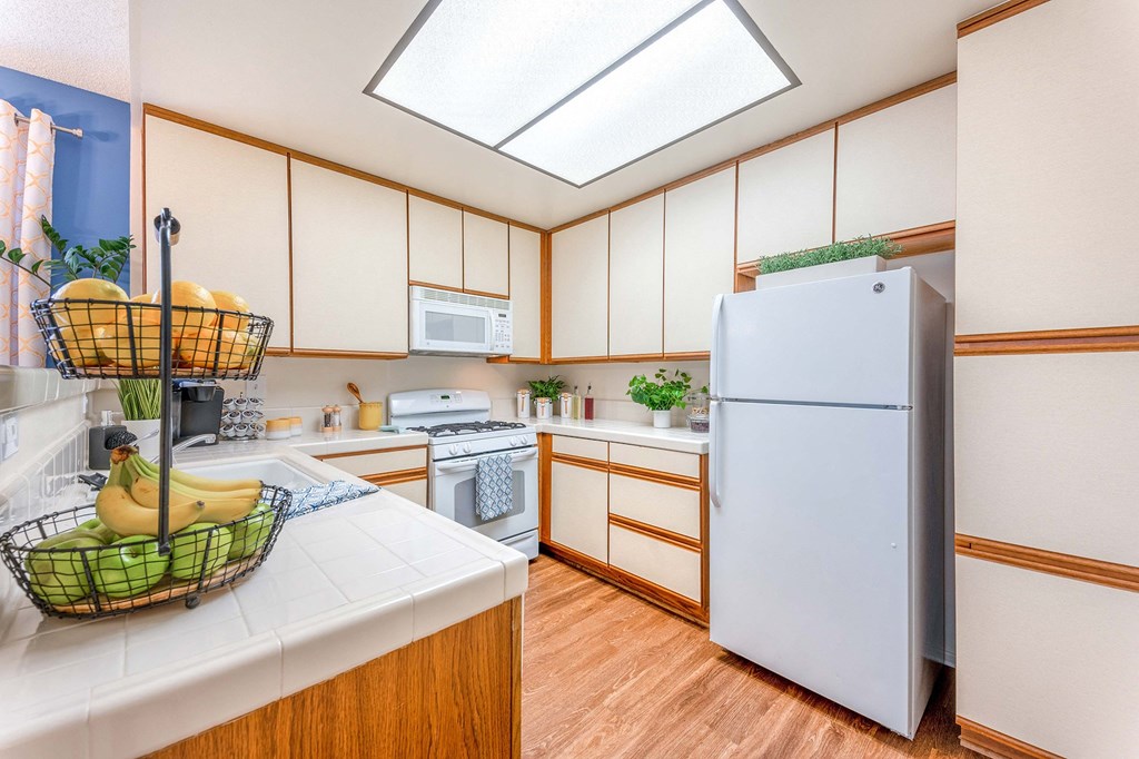 a kitchen with white cabinets and a white refrigerator