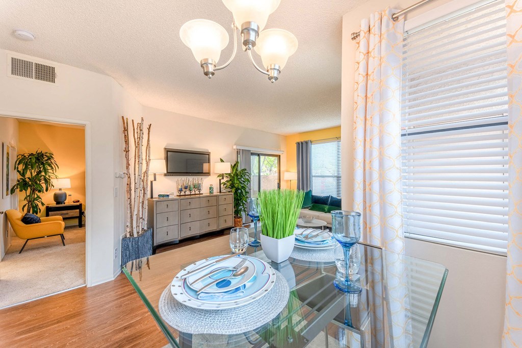 a dining room with a glass table and a living room