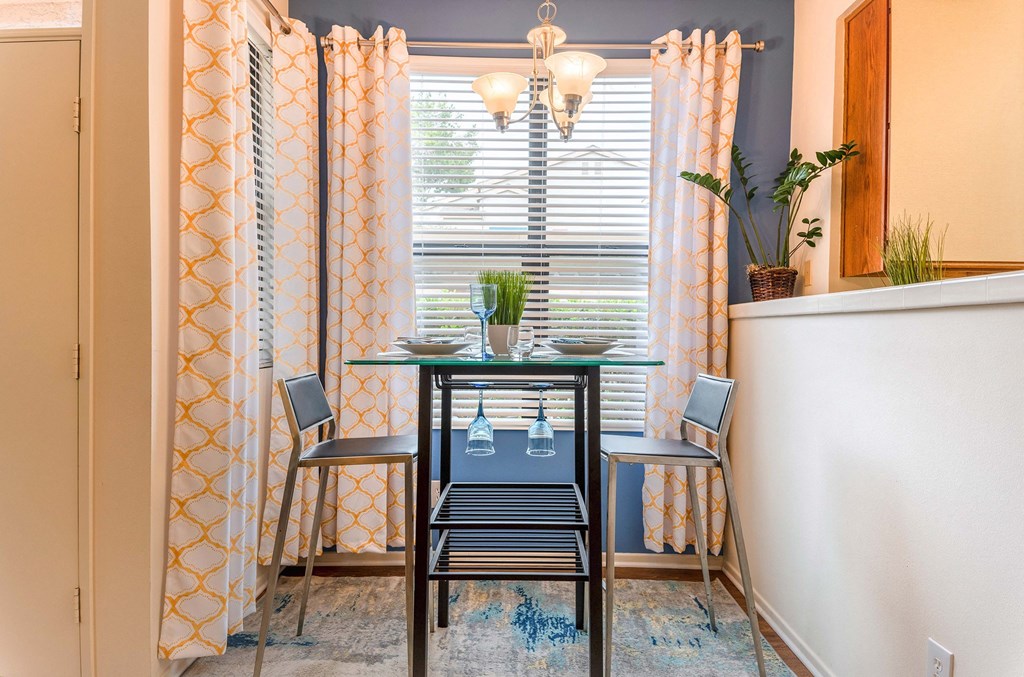 a dining room with a table and chairs and a window