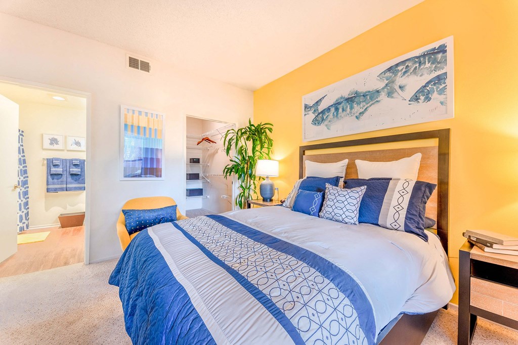 a bedroom with a blue and white bed and a bathroom