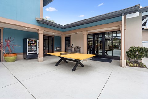 A yellow table is in the middle of a patio.