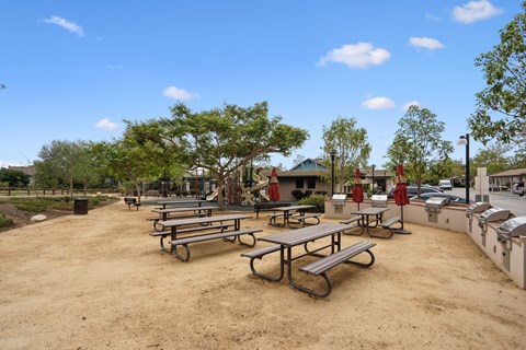 A park with picnic tables and trees.