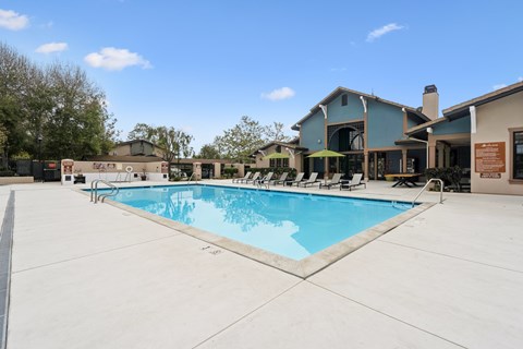 A large swimming pool in front of a house.