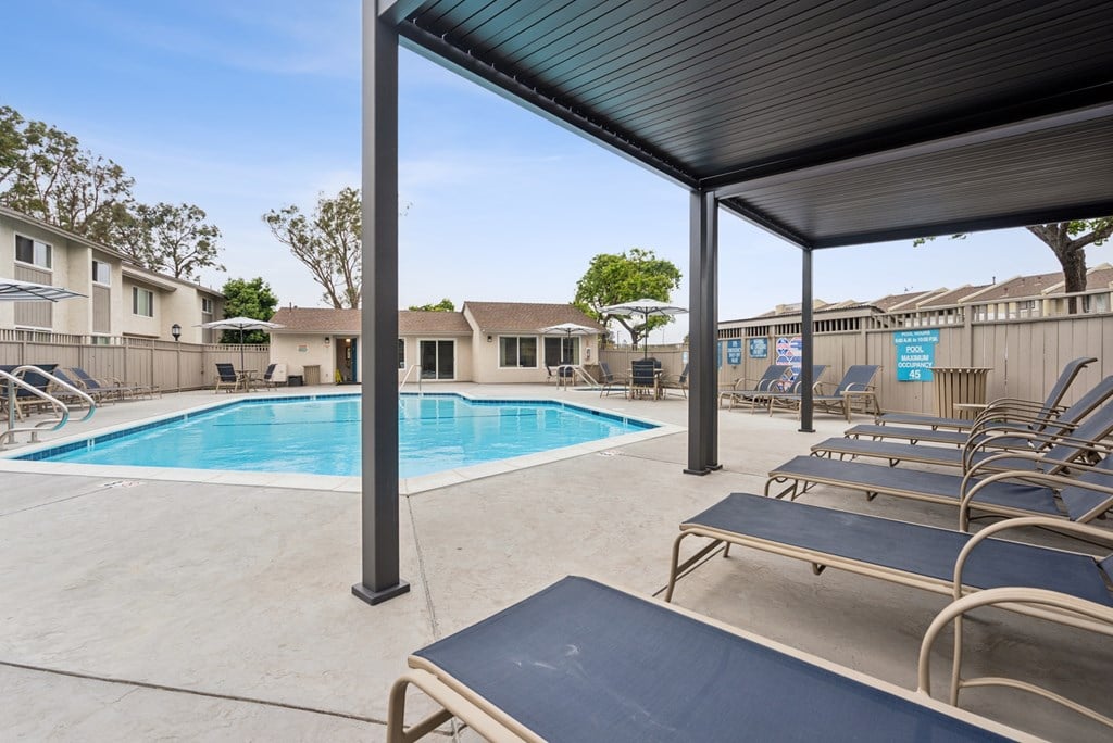 A pool with a blue cover and a metal bench.