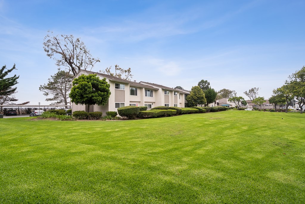 A large grassy field in front of a building.