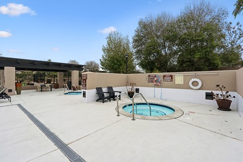 A pool with a slide and a hot tub in a backyard.