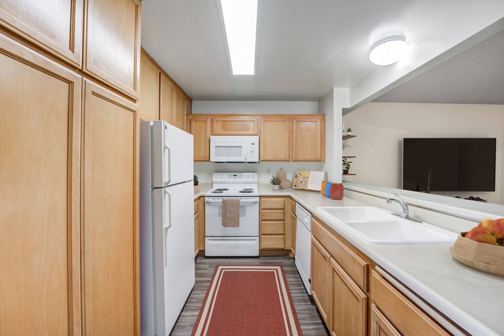 a kitchen with white appliances and wooden cabinets