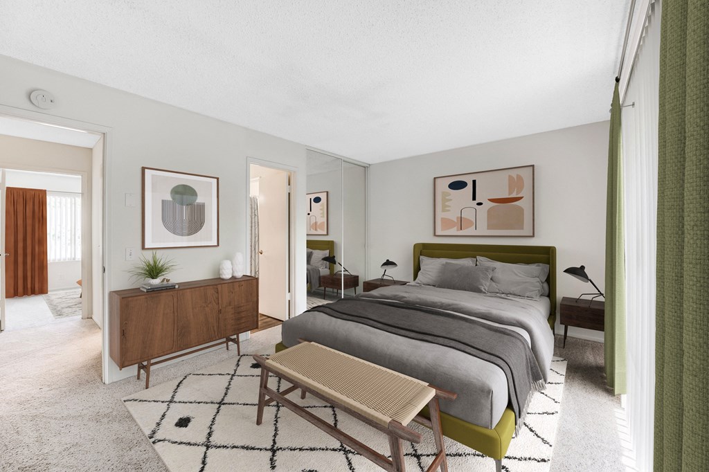 a bedroom with gray walls and a large bed with a green headboard