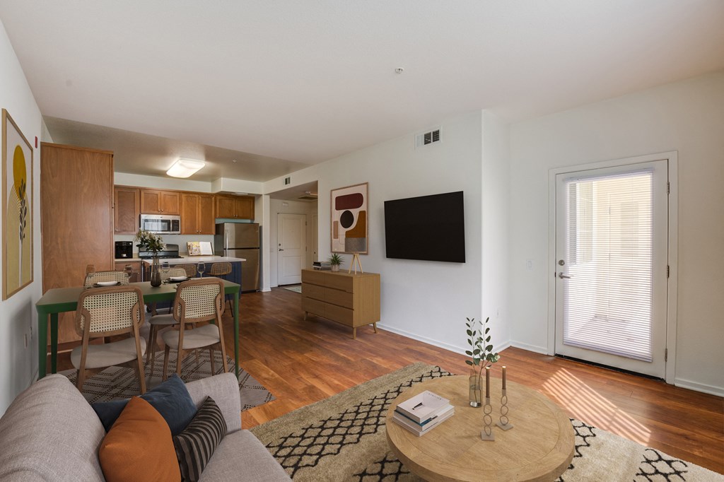 a living room with a couch a table with chairs and a television on the wall