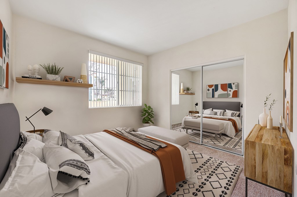 One, Two, and Three-Bedroom Apartments in Santa Maria, CA - Hancock Terrace - Spacious Bedroom with Carpet Flooring, a Window with Blinds, and a Closet with Mirror Sliding Doors.