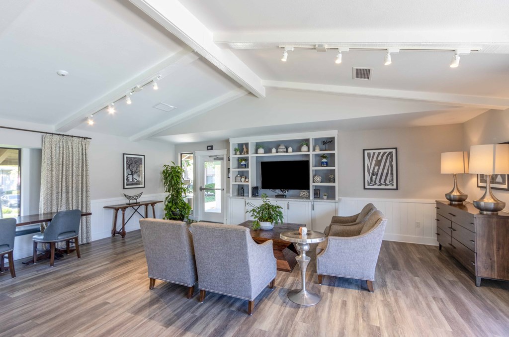 a living room with couches and chairs and a tv