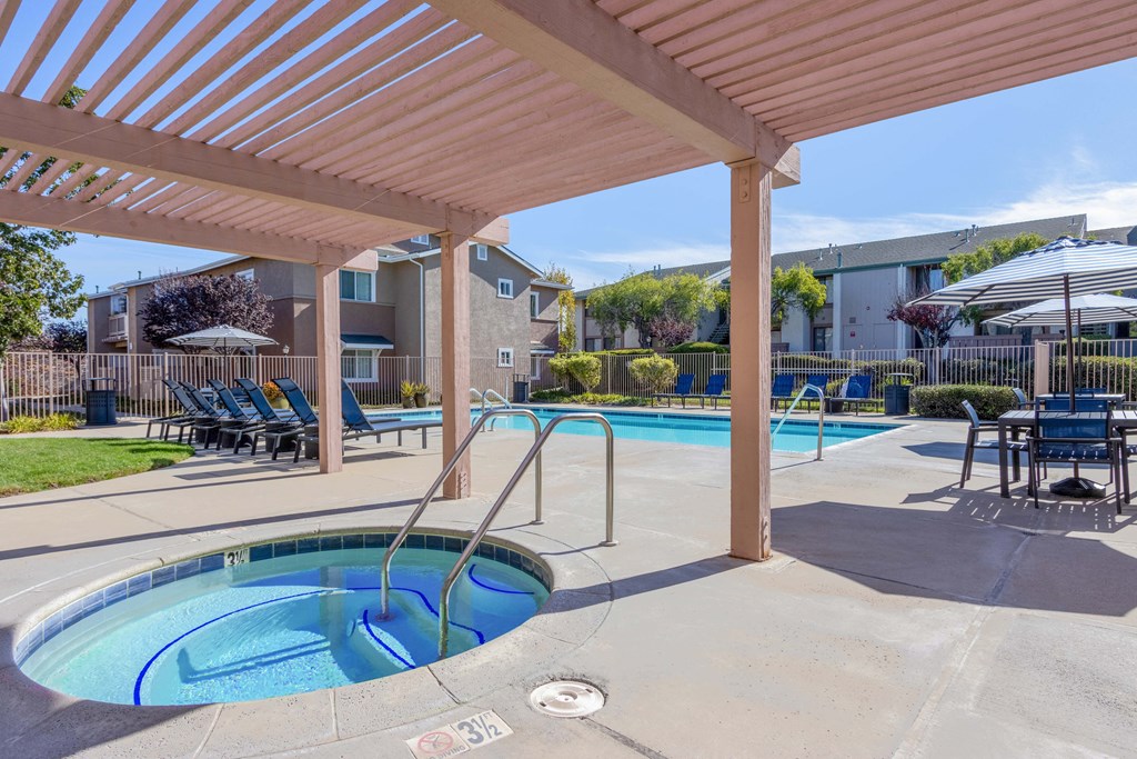 2-BR Apartments in Orcutt, CA - Knollwood Meadows - Poolside Hot Tub/Spa Under Pergola with Chairs, Tables, Lounge Chairs, And Umbrellas
