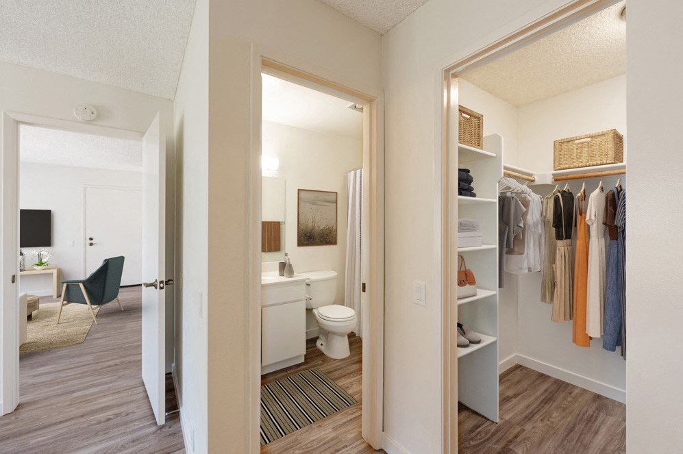 a closet with a mirror and a bathroom with a toilet