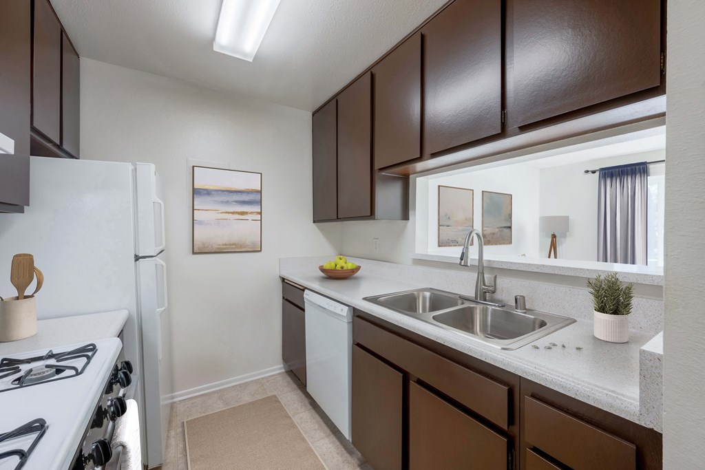 A kitchen with brown cabinets and a white stove.