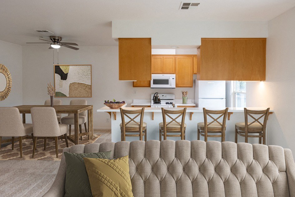 a living room with a couch and a kitchen with a table and chairs