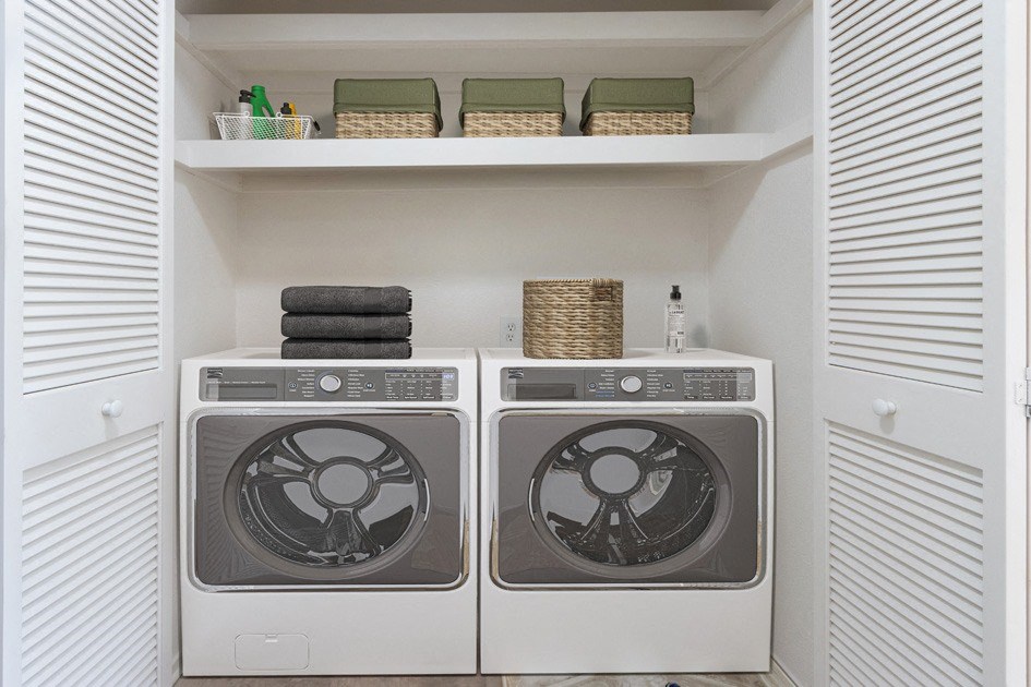 Lompoc, CA, Apartments Near Walmart - Oceanwood - Laundry Closet with Washer, Dryer, Shelves, and Baskets.