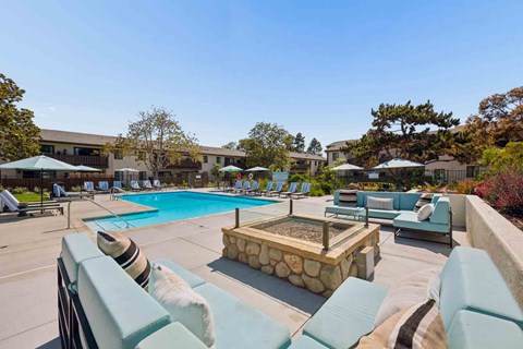 A pool area with a hot tub and lounge chairs.