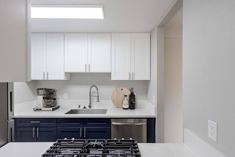 a kitchen with white cabinets and a stove and a sink