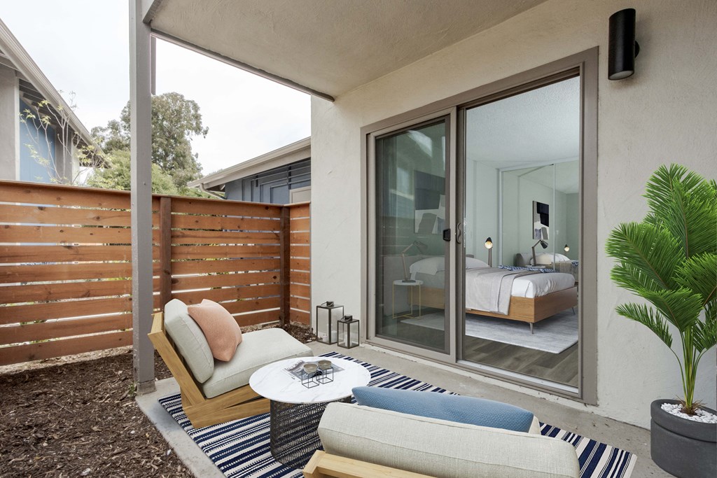 a bedroom has a patio with a couch and a coffee table