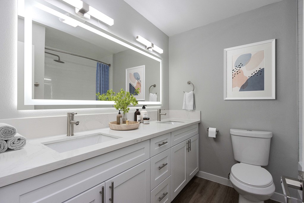 a white bathroom with a large mirror and a toilet