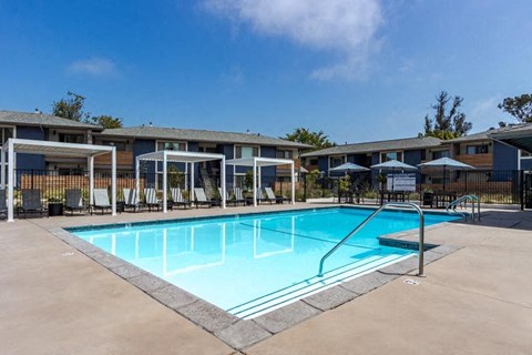 a swimming pool with chairs and umbrellas around it