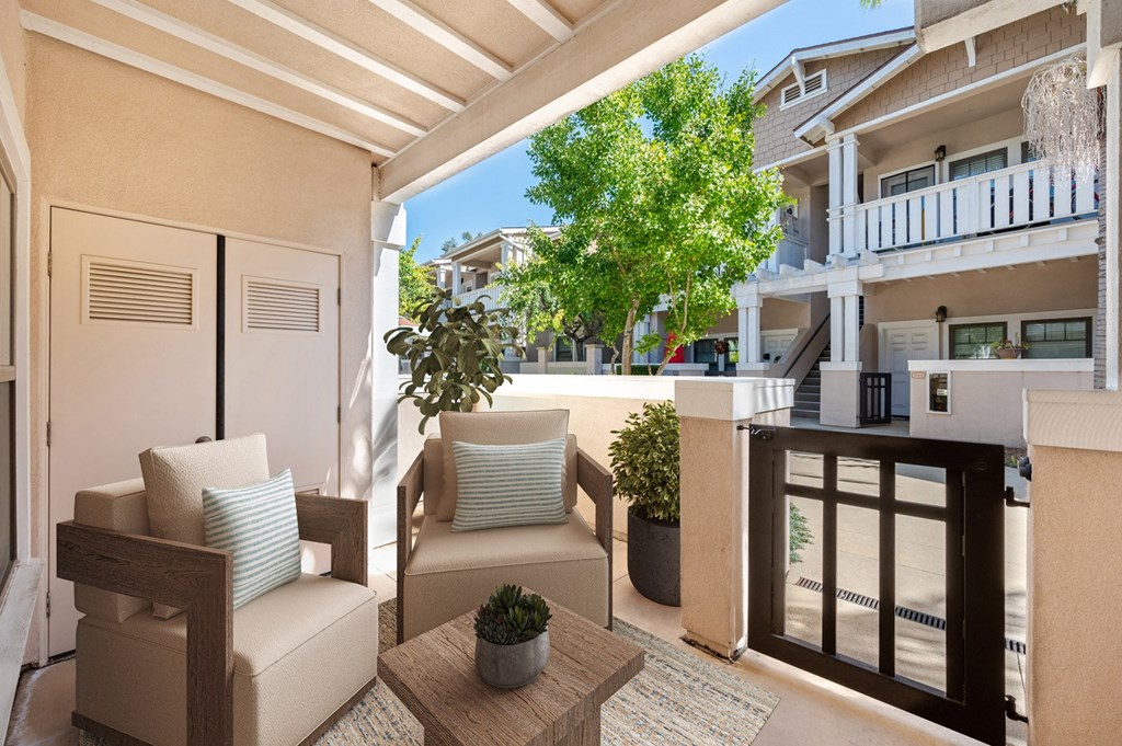 a patio with chairs and a table and a balcony