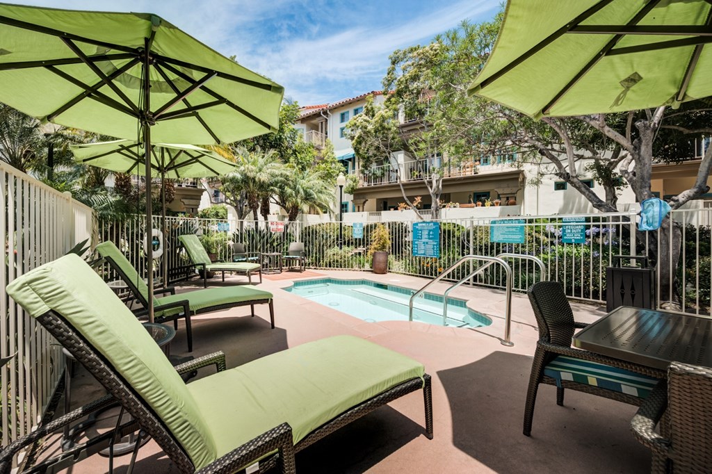 a pool with lounge chairs and umbrellas