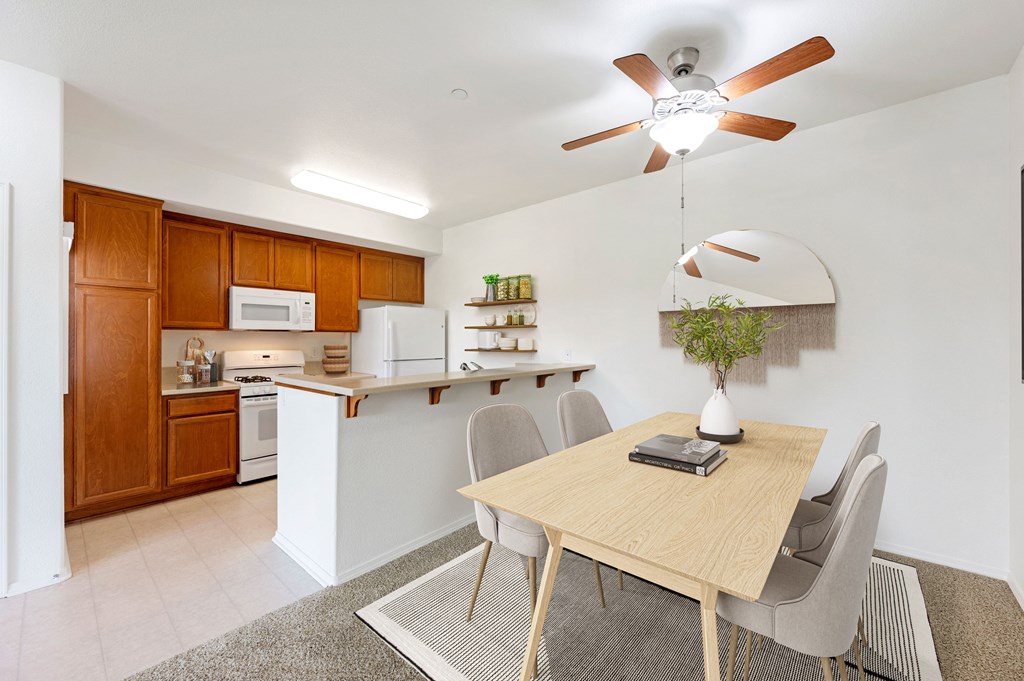 Apartments in Santa Maria, CA, for Rent - Siena - Dining Room with Carpeted Floor, Dining Table with 4 Chairs, Ceiling Fan, and View of Kitchen