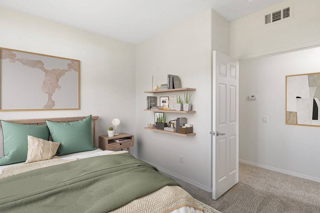 Santa Maria, CA Apartments Near Vandenberg Air Force Base - Siena - Bedroom with Large Bed, Nightstand, and Floating Bookshelves.