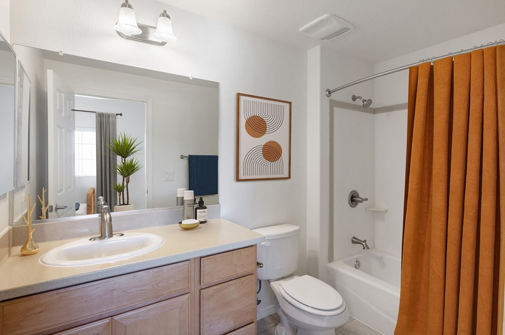a bathroom with a white sink and toilet next to a white bathtub with a shower curtain
