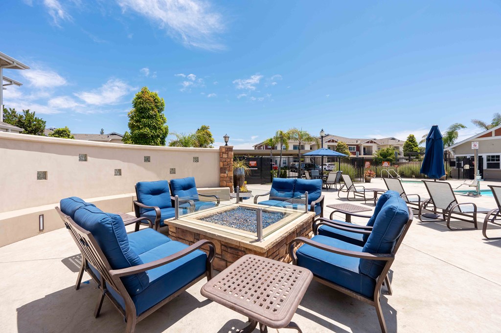 Santa Maria, CA Apartments - Siena - Poolside Firepit with Blue Lounge Chairs.
