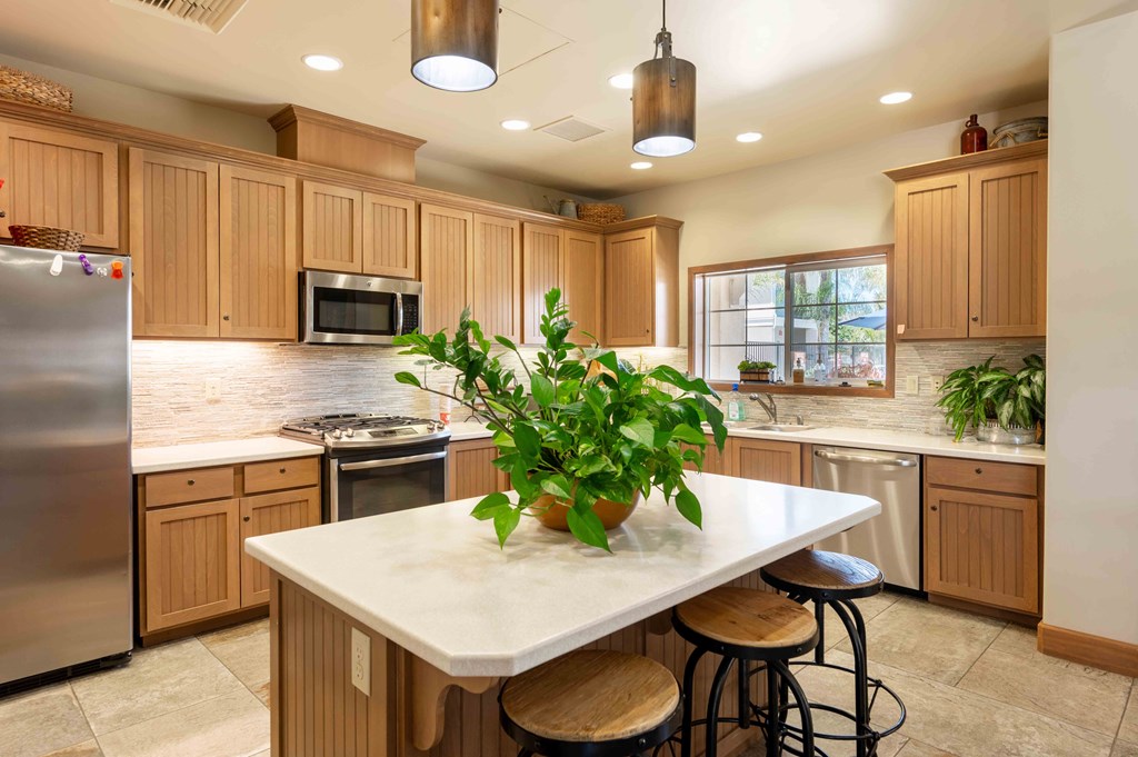 a kitchen with wooden cabinets and a large island with a potted plant