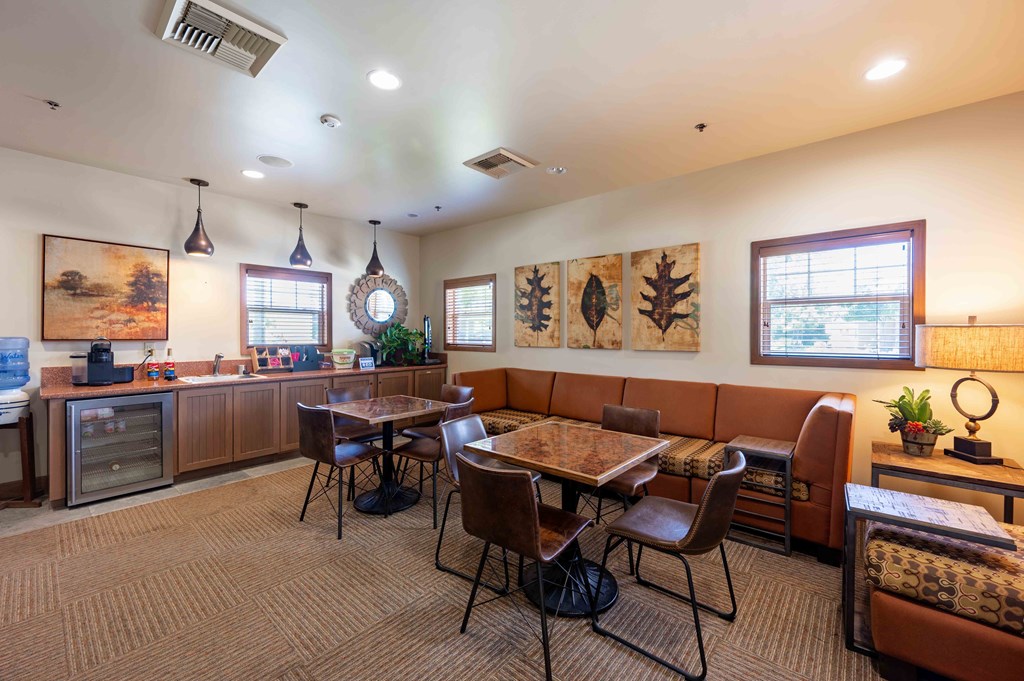 One-Bedroom Apartments in Santa Maria, CA - Siena - Coffee Lounge with Kitchenette, Tables, Chairs, and Long Leather Sofa.