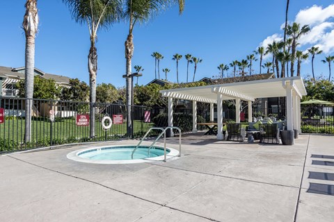 Goleta, CA Apartments Near UC Santa Barbara - Sumida Gardens - Spa beside Pergola with Patio Furniture, and Palm Trees.