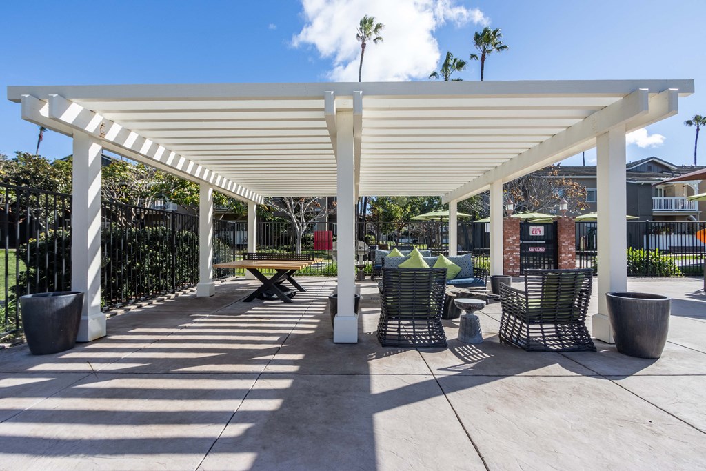 a covered patio with tables and chairs under a white roof
