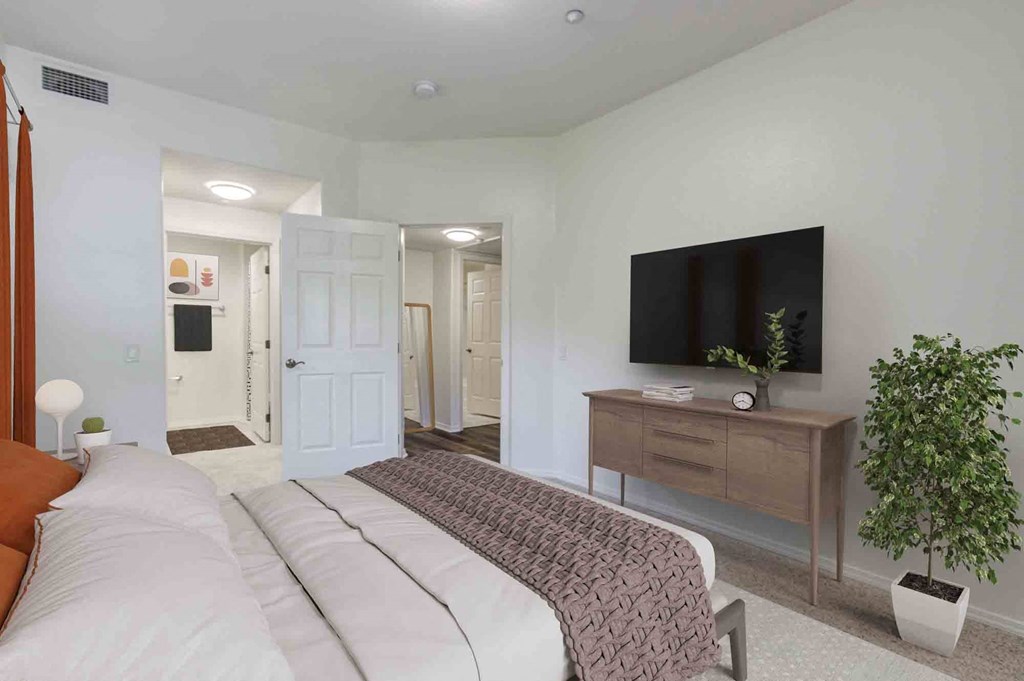 a master bedroom with a large bed and a tv on the wall