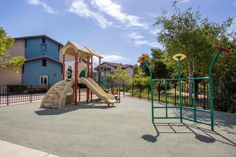 a playground with a slide and monkey bars in a park