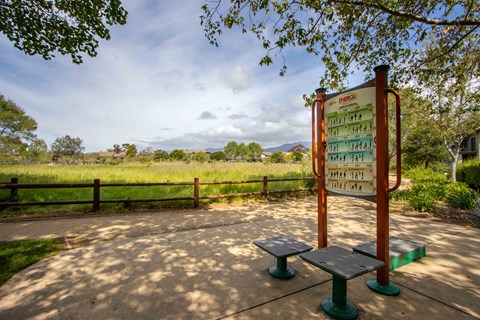 a bench and a sign next to a field