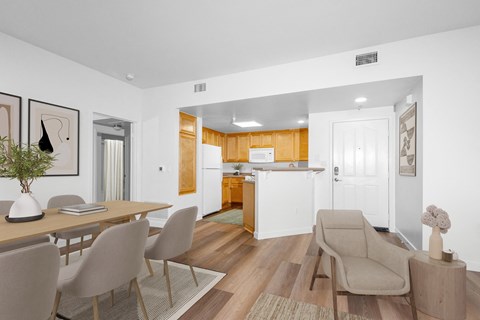 Apartments Near Starbucks in Goleta, CA - Willow Springs - Dining Area with Contemporary Laminate Wood-Style Flooring, Dining Table, Chairs, and View of Kitchen.