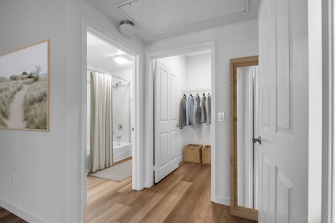 a hallway with a door to a closet and a bathroom with a shower