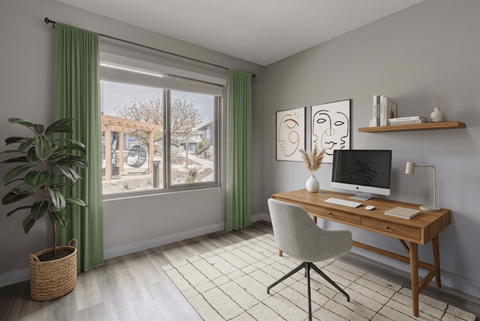 A room with a desk, chair, and a plant.