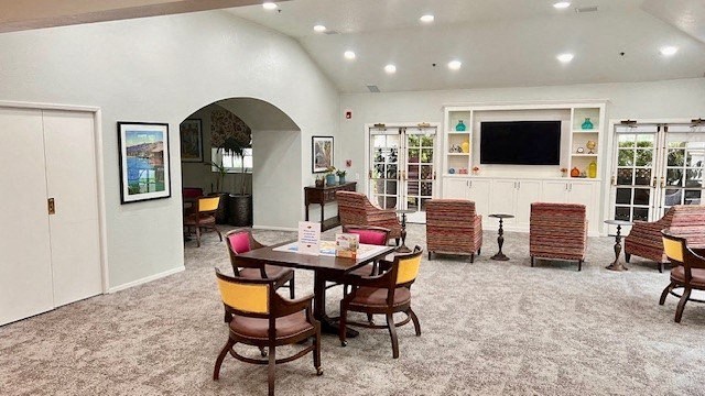 Santa Barbara, CA Senior Living - Rancho Franciscan - Clubhouse with French Doors, Television Media Center with Shelves, Tables, and Chairs.