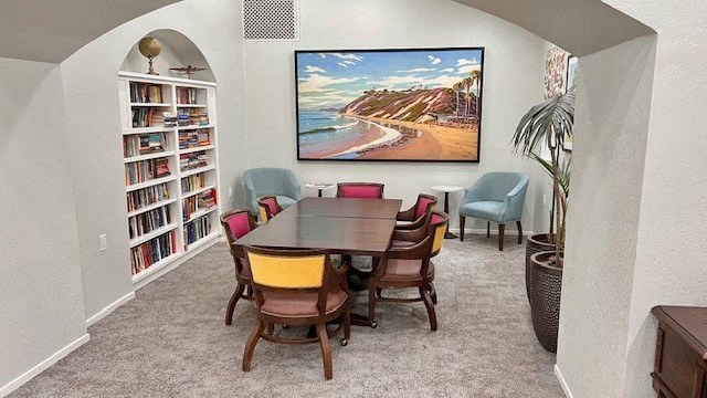 a dining room with a table and chairs and a painting on the wall