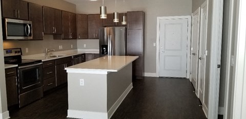 A kitchen with dark brown cabinets and a white island.