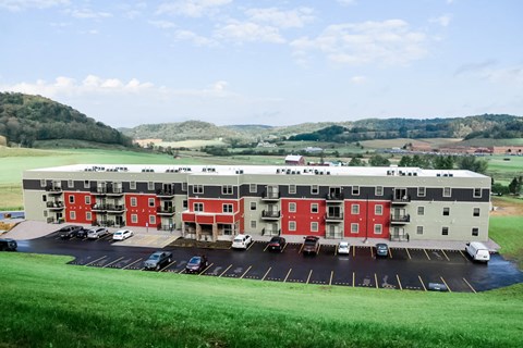 A large red and white building with a parking lot in front.