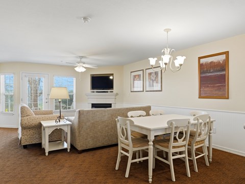 A dining room with a white table and chairs.