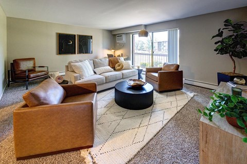 A living room with a brown sofa, a white couch, and a black coffee table.