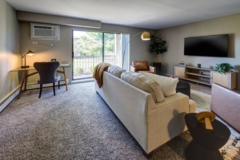 A living room with a couch, chair, and television.