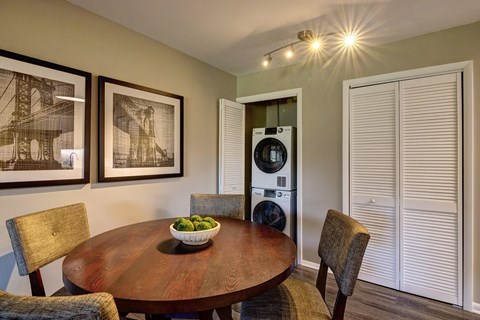 A dining room with a wooden table and chairs.