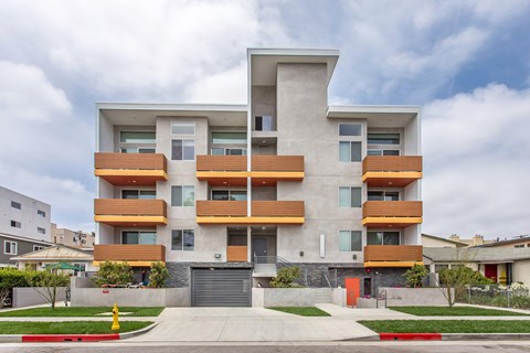 A modern apartment building with a mix of wood and concrete exterior.